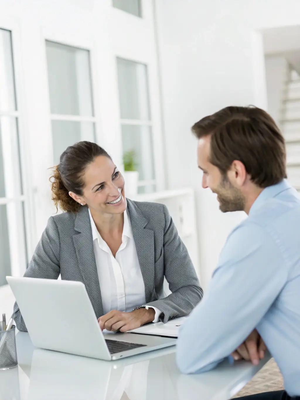 A professional coach in a modern office setting, listening attentively to a client, symbolizing personalized support and guidance.